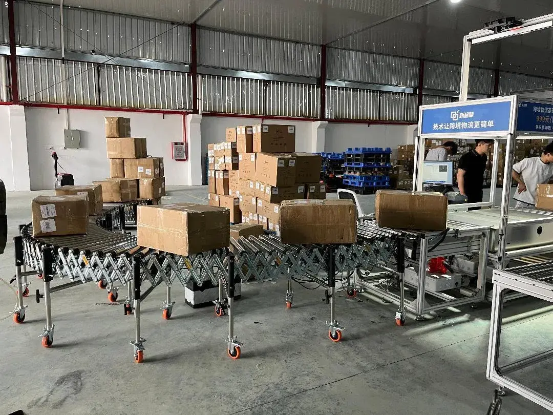 无月台平地装卸怎么提效：耐力输卸神器（广东）实业有限公司动力滚筒伸缩线与液压升降爬坡机方案