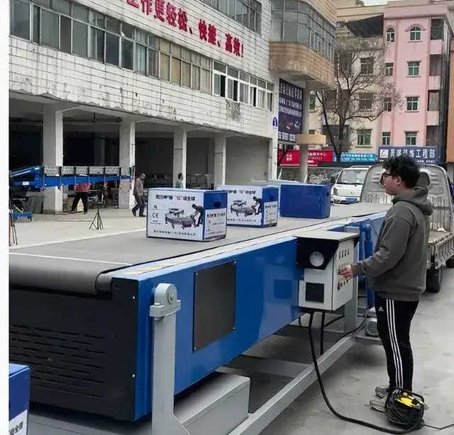 工作人员在车厢内配合伸缩皮带机整理货物
