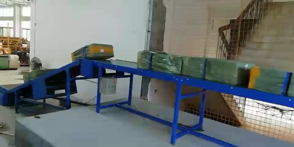 Taisbeanadh sruth-obrach: an conveyor telescopach a’ togail bathair bhon loidhne giùlain taigh-bathair agus a’ sìneadh a-steach dhan bhogsa-luchd airson luchdachadh/dì-luchdachadh